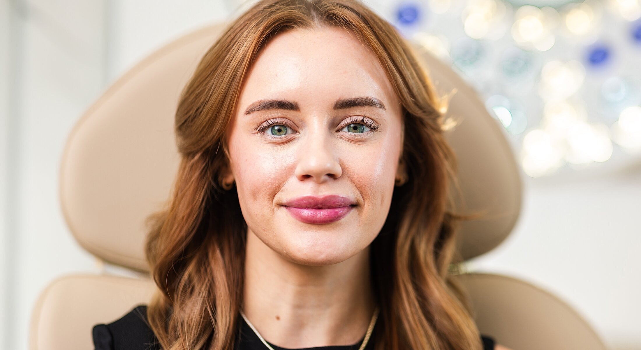 Smiling woman with green eyes in a salon.