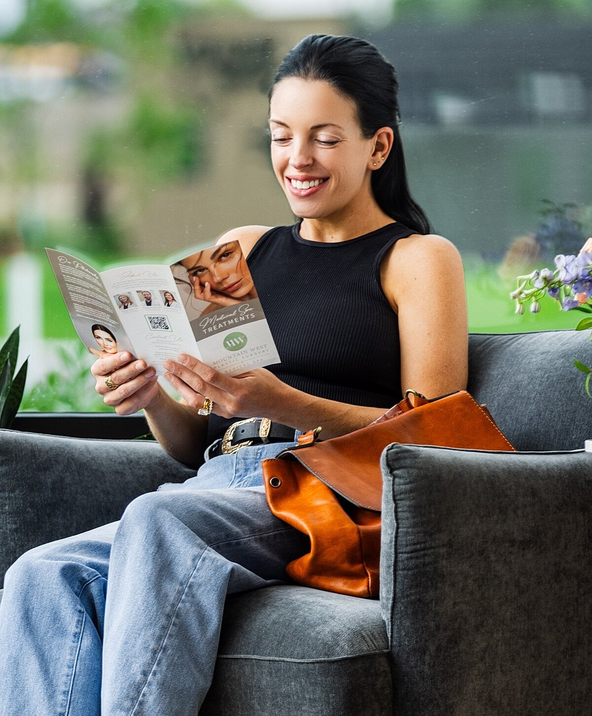 Woman reading a brochure while sitting comfortably.