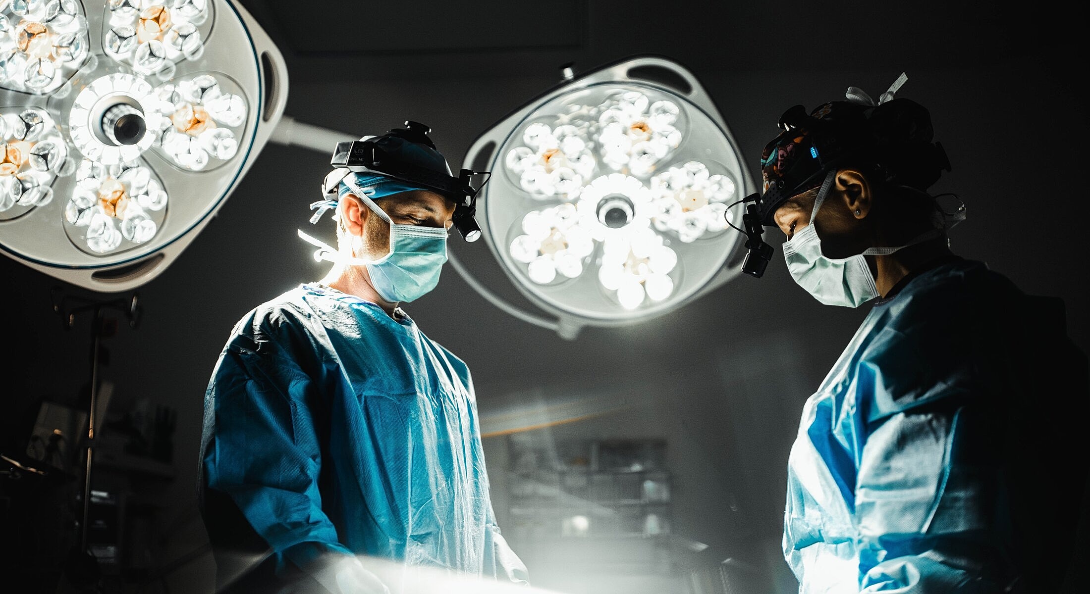Surgeons working under bright operating lights.